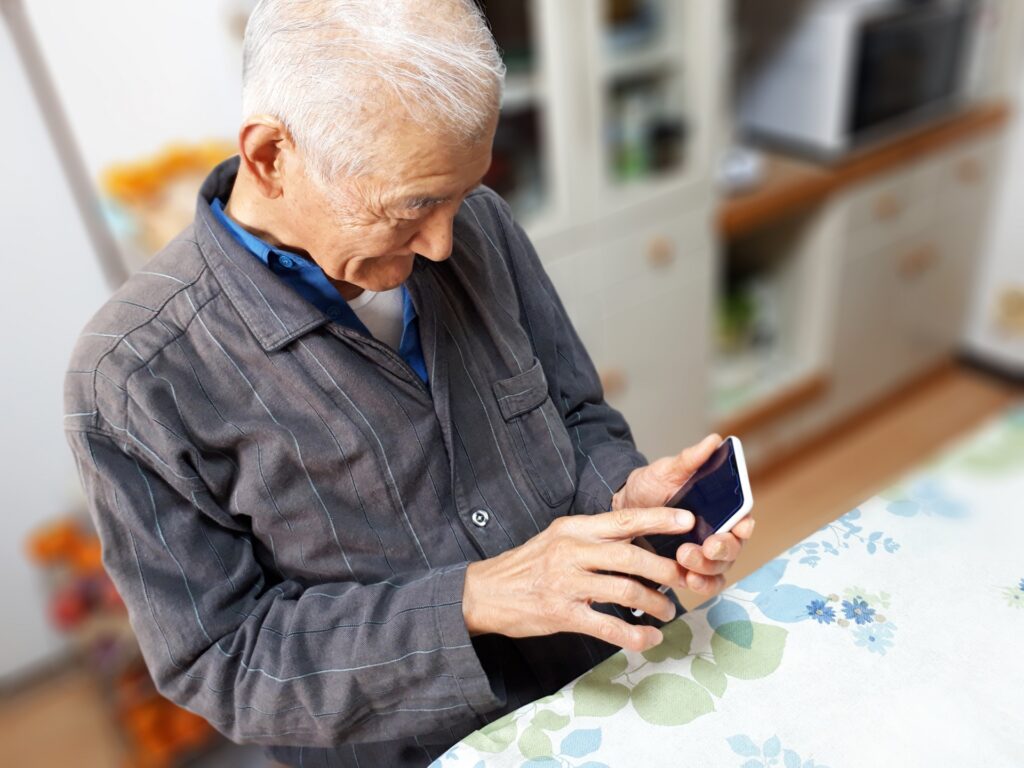 スマートフォンを操作する高齢の男性